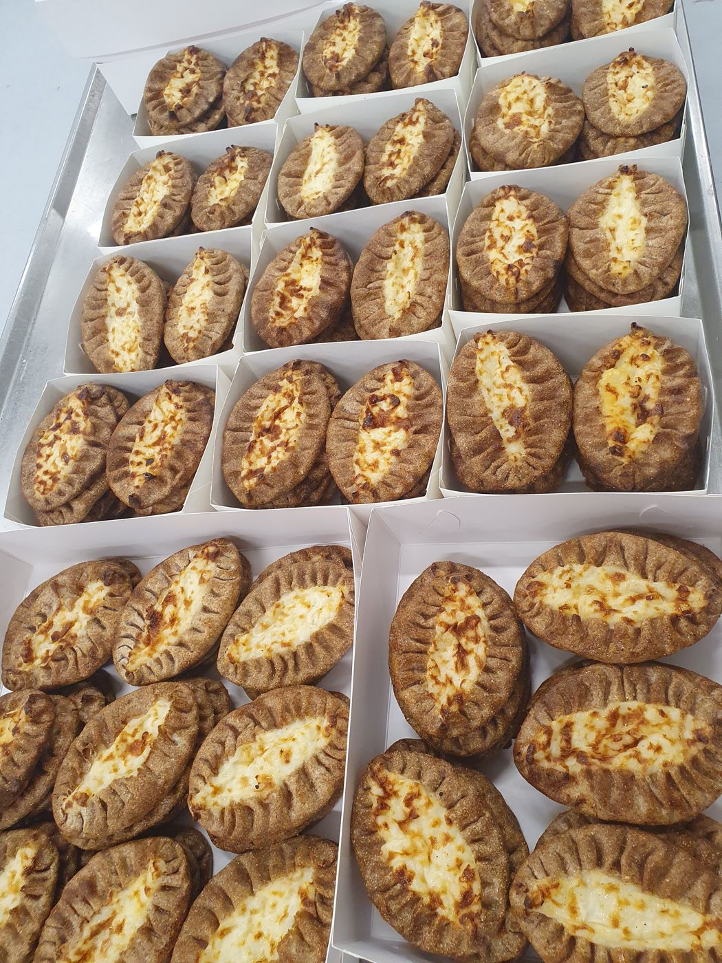 Käsin tehtyjä karjalanpiirakoita laatikoissa
